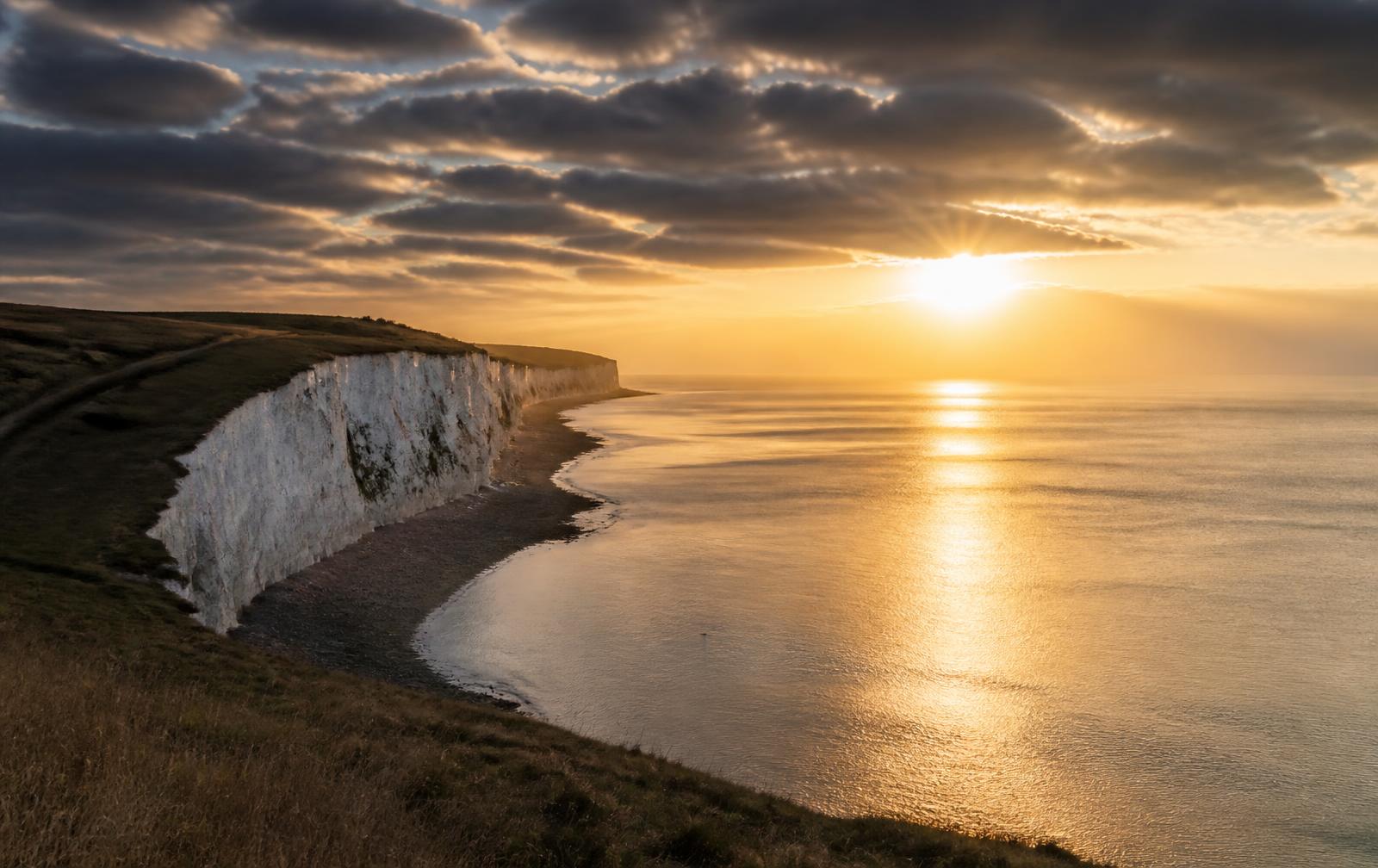 British chalk coastline at dawn with light breaking through the clouds